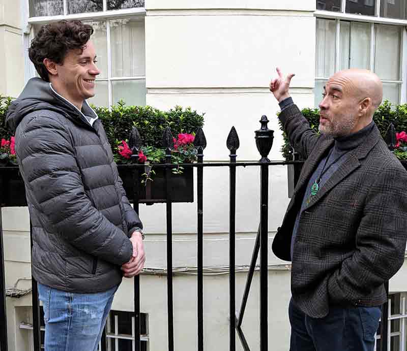 Guiding and pointing to a white rendered London building.